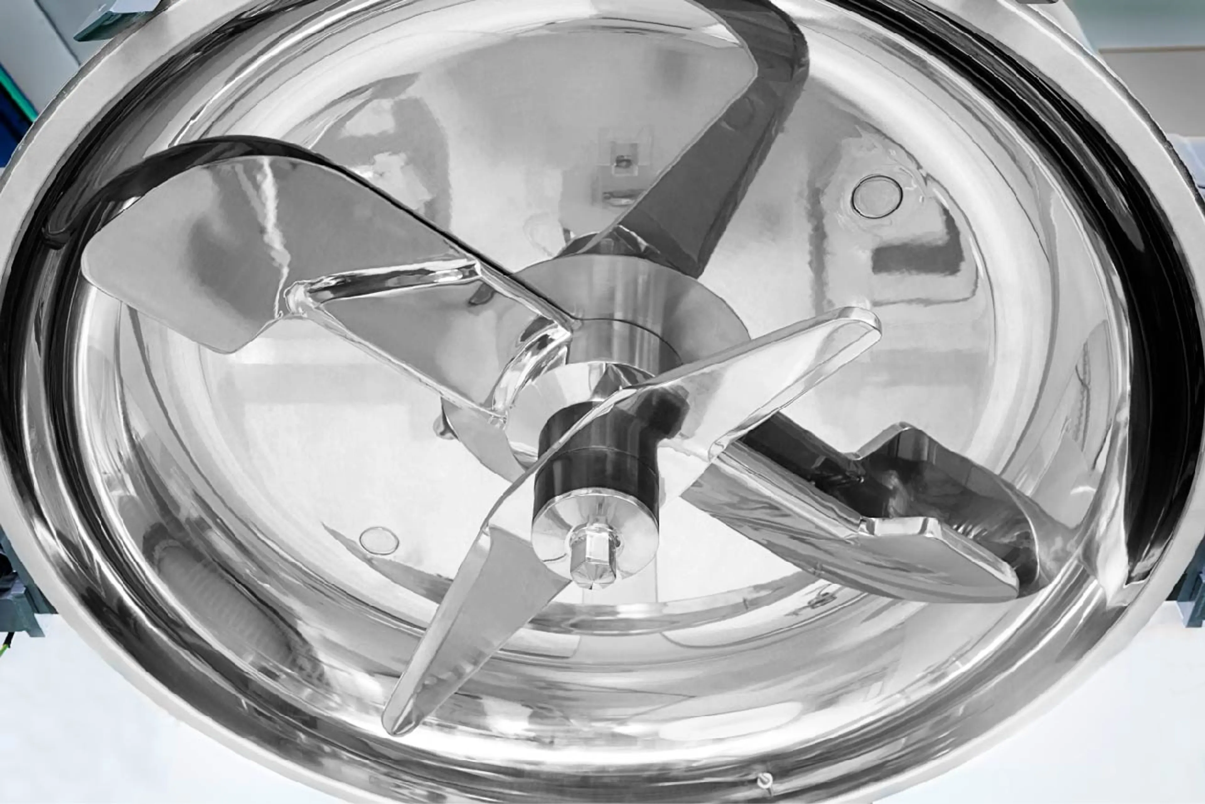 detail of machinery with rotating stainless steel blades for mixing primary plastics